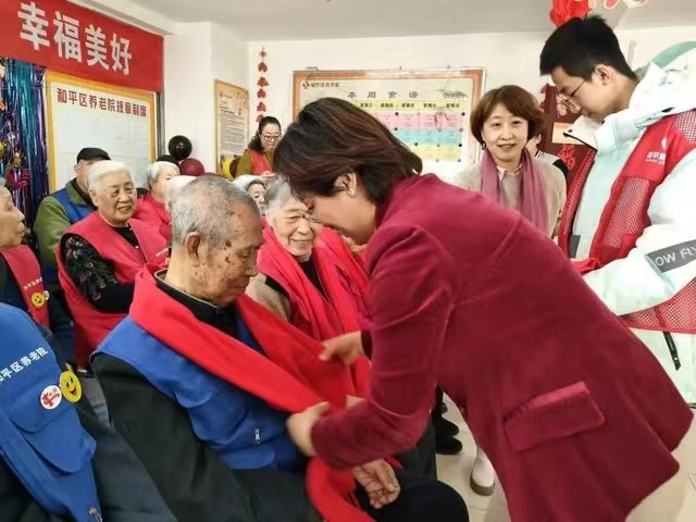 《晚晴报》社长为老人戴上红围巾.png